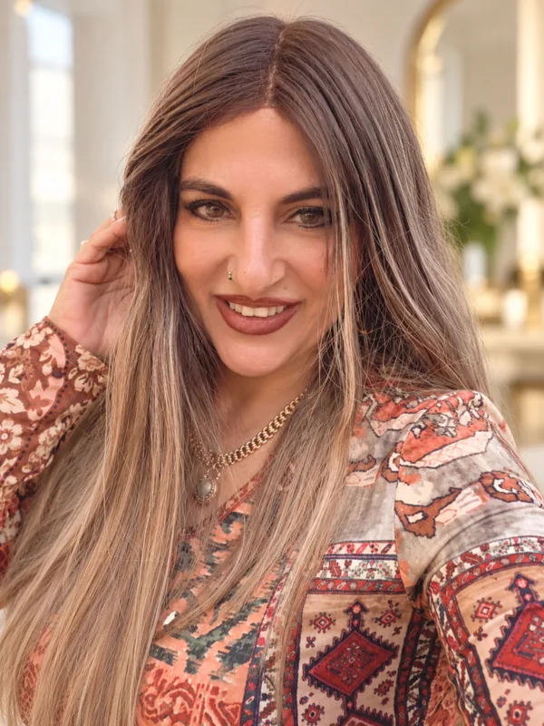 טליה צעידי נוגעת בשיערה ומחייכת אל המצלמה, בסטודיו